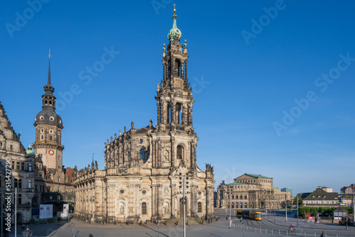 Dresden, der Schloßplatz mit Schloß, Hofkirche und Semperoper in morgendlichem Sonnenlicht, eine Straßenbahn fährt vorbei