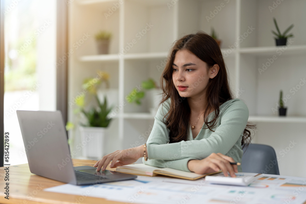 Young accountant freelance working in office using laptop with calculator. concept business finance and accounting, tax, debt concept Young accountant freelance working in office using laptop with calculator. concept business finance and accounting, tax, debt concept