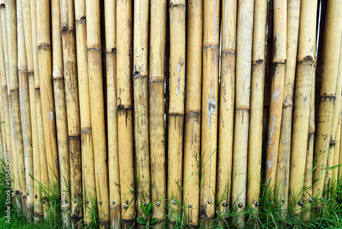 Old brown tone bamboo simple wall or Bamboo fence texture background for exterior design vintage tone. Brown bamboo stick pattern backdrop. Local area urban house protection from thief.