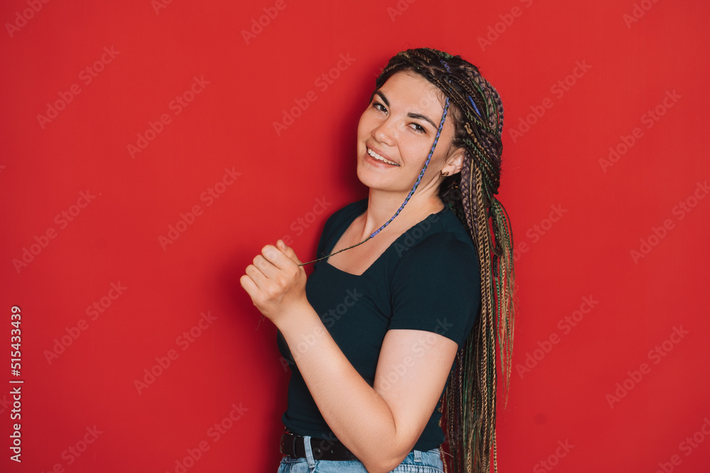 Girl with multi-colored pigtails against a red background. Girl with multi-colored pigtails against a red background.