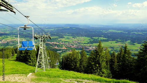 Blick von Seilbahn auf dem Hörnle auf Bad Kohlgrub im Ammergau mit Wald und grünen Wiesen bei Sonne