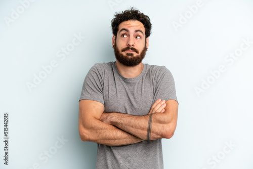 Fototapeta young adult bearded man shrugging, feeling confused and uncertain, doubting with