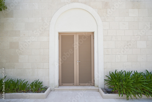 louvered entrance door on the wall with stone finish photo