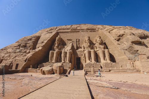 The main view of an Entrance to the Great Temple at Abu Simbel with Ancient Colossal statues of Ramesses II, seated on a throne and wearing the double crown of Upper and Lower Egypt
