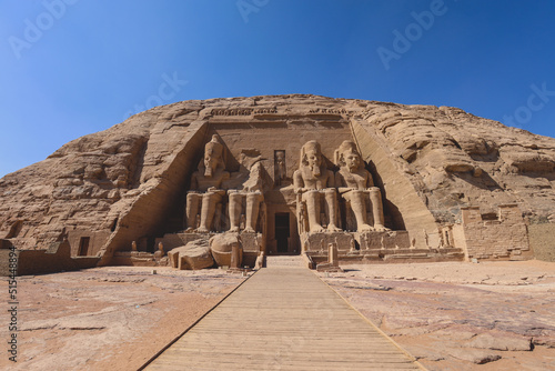 The main view of an Entrance to the Great Temple at Abu Simbel with Ancient Colossal statues of Ramesses II  seated on a throne and wearing the double crown of Upper and Lower Egypt