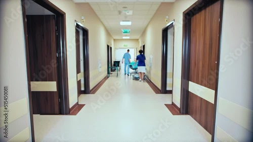 Medical staff walking away in hospital corridor photo