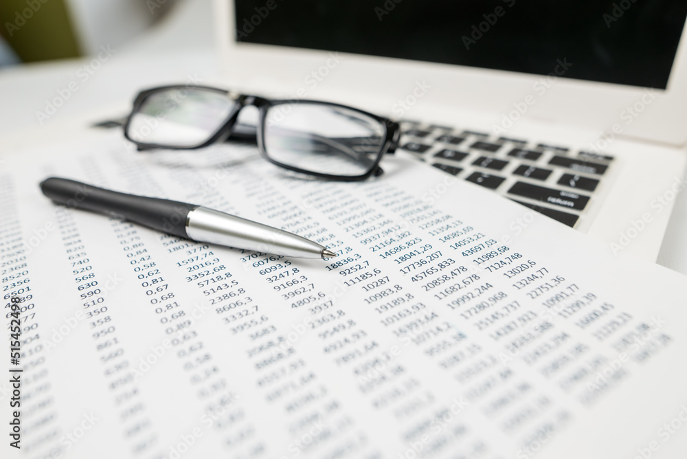 The concept of financial statistics, analysis. Laptop and documents with different numbers The concept of financial statistics, analysis. Laptop and documents with different numbers