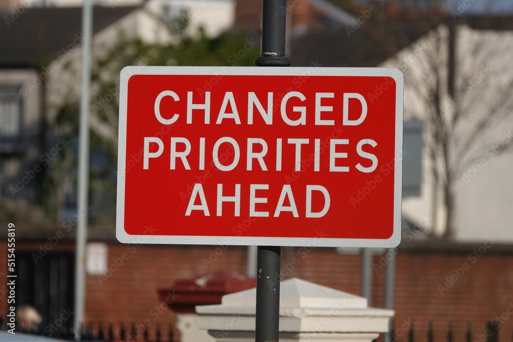 A red sign stating Changed Priorities Ahead. A red sign stating Changed Priorities Ahead.