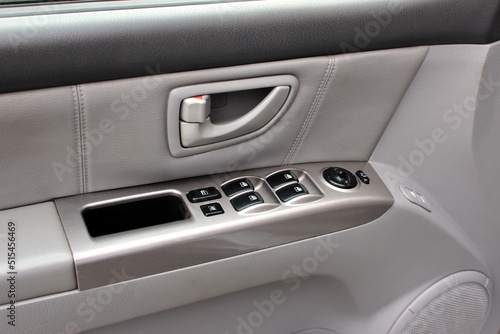Door handle with windows controls and adjustments in interior classic SUV. Window switches.