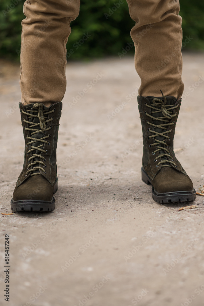 Military man in dark green leather tactical boots Military man in dark green leather tactical boots