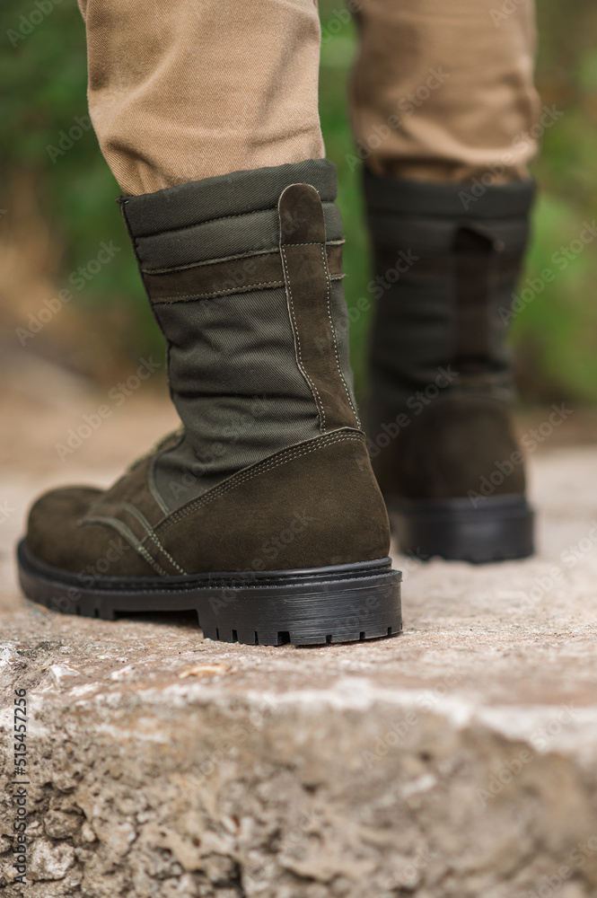 Military man in dark green leather tactical boots Military man in dark green leather tactical boots