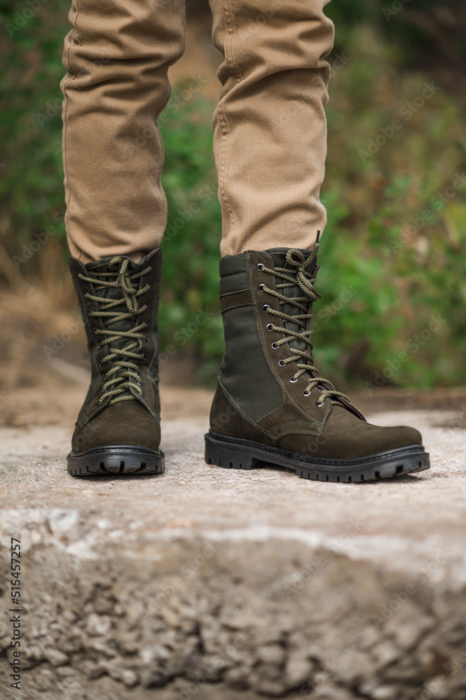 Military man in dark green leather tactical boots Military man in dark green leather tactical boots