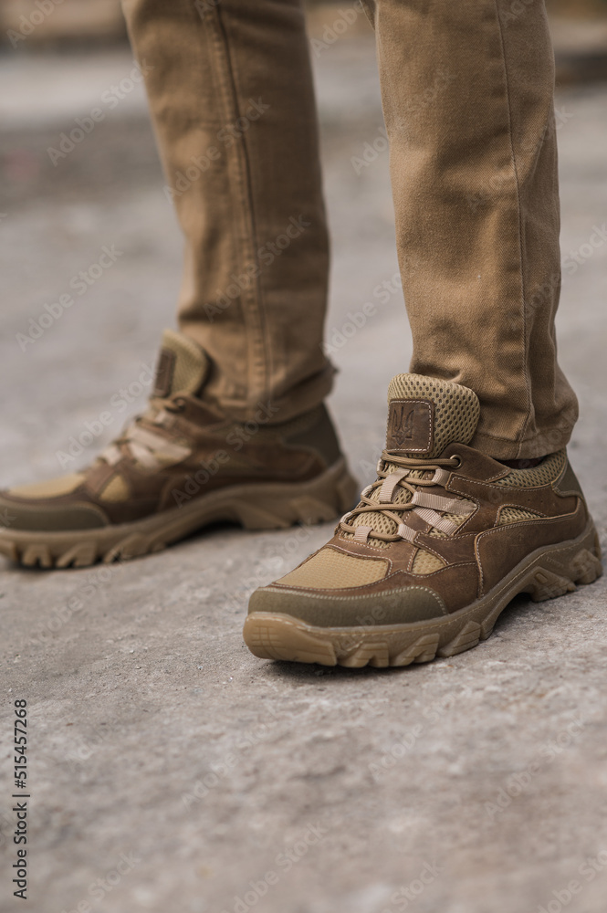 Military man in beige leather tactical sneakers