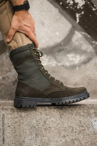 Military man in dark green leather tactical boots © flywish