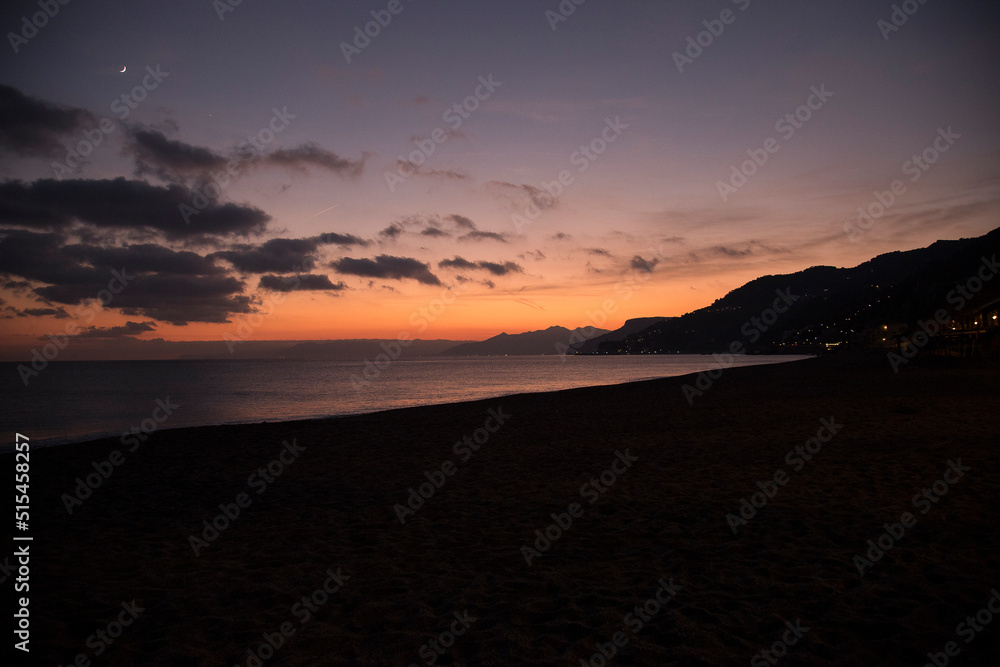 Sunset on the sea.
Seascape at sunset, with beach and distant lights of some countries.