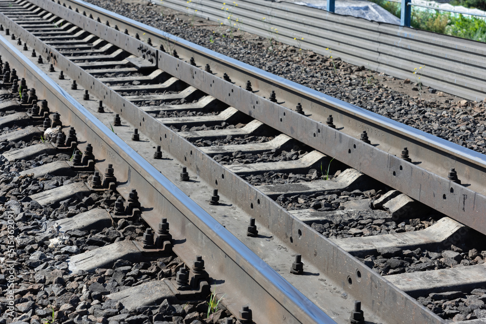 Metal rails of a railway train, road into the distance, railway station Metal rails of a railway train, road into the distance, railway station