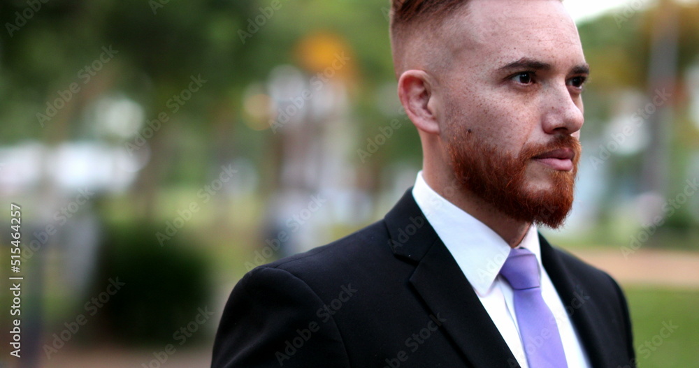 Man wearing suit standing outside at park, irish ginger executive person outdoors Man wearing suit standing outside at park, irish ginger executive person outdoors