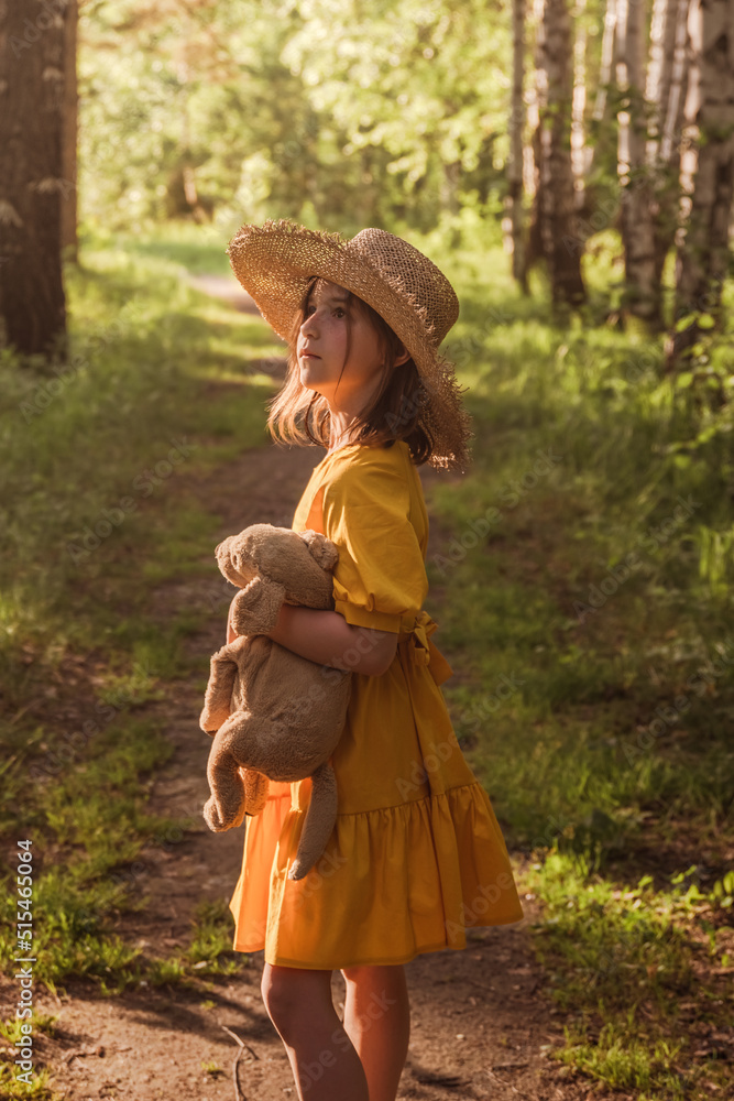 cute little girl in a yellow dress and straw hat walking through the ...