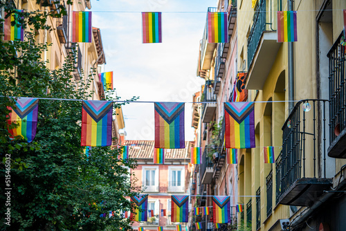 Streets of the Madrid neighborhood of Chueca adorned with rainbow flags on the occasion of LGBTI and gay pride week, during a sunny summer day photo