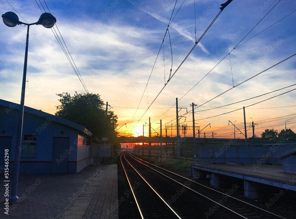 Sunset from the platform of the railway station of a small suburban station. Waiting for the train