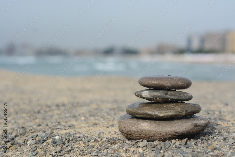 Stack of stones on sandy beach near sea, space for text Stack of stones on sandy beach near sea, space for text