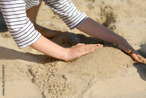 Child making sand castle on beach, closeup