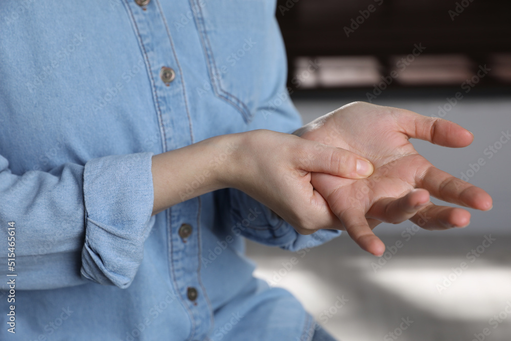 Woman suffering from trigger finger at home, closeup Woman suffering from trigger finger at home, closeup