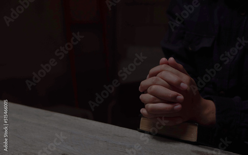 Hands folded in prayer on a Holy Bible in church concept for faith  spirituality and religion  woman praying on holy bible in the morning. woman hand with Bible praying.