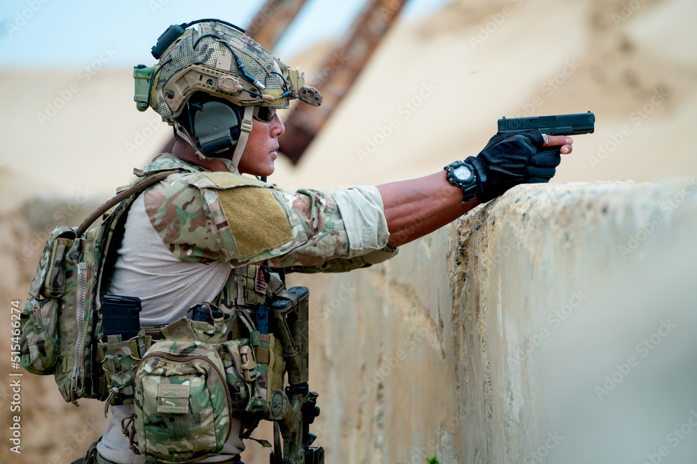 Fototapeta premium Military or soldier point gun and stay behind of concrete wall in the battle field for fighting to enemy.