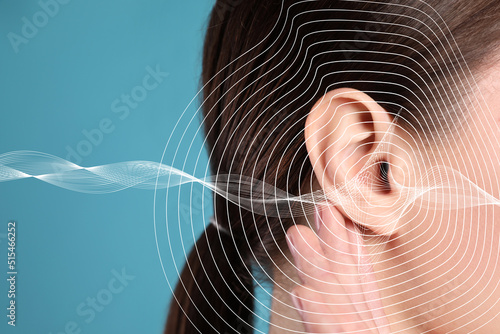 Hearing loss concept. Woman and sound waves illustration on light blue background, closeup photo