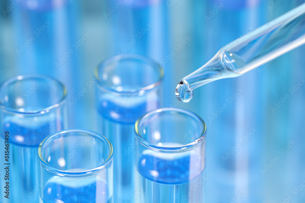 Dripping reagent into test tube on blurred background, closeup and space for text. Laboratory analysis Dripping reagent into test tube on blurred background, closeup and space for text. Laboratory analysis