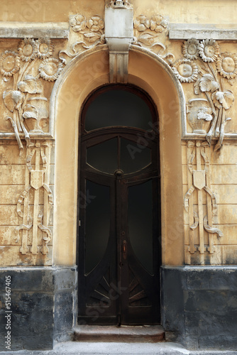 Entrance of house with arched wooden door and beautiful moldings © New Africa