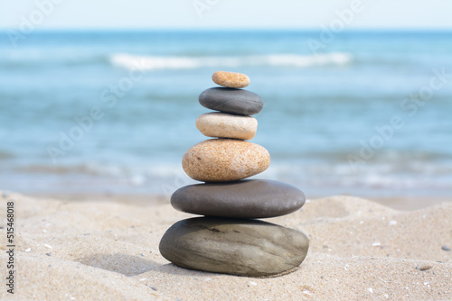 Stack of stones on sandy beach near sea