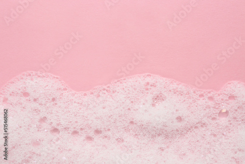 Fluffy bath foam on pink background, top view. Space for text