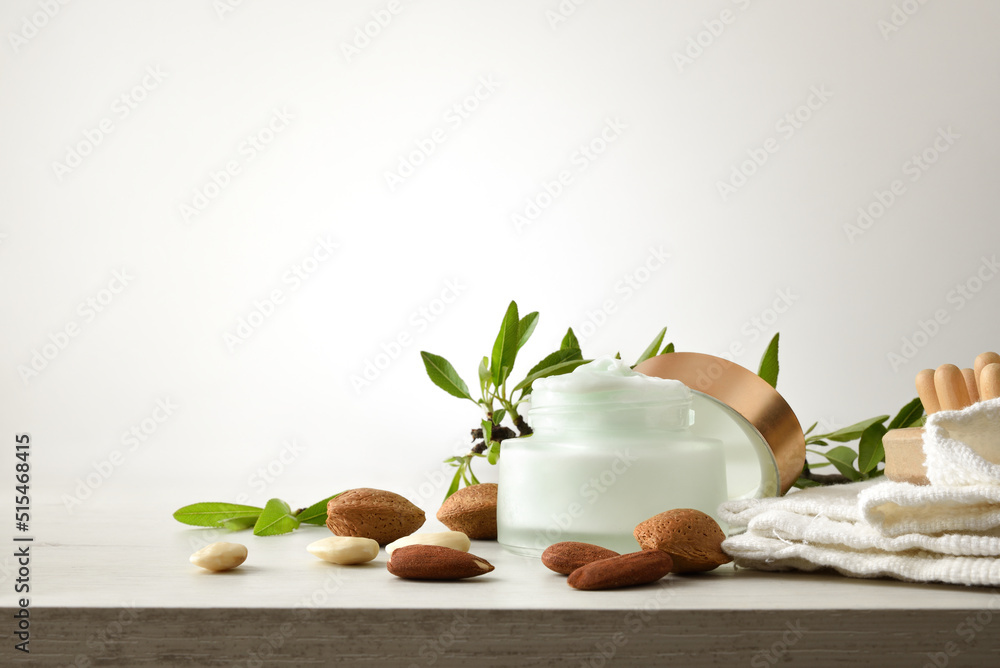 Moisturizing cream with almond extract on wooden table isolated white Moisturizing cream with almond extract on wooden table isolated white