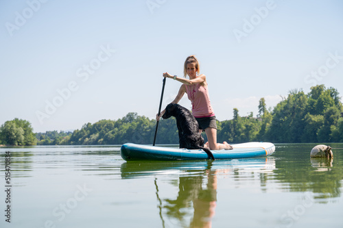 Dog owner and her labrador on sup board