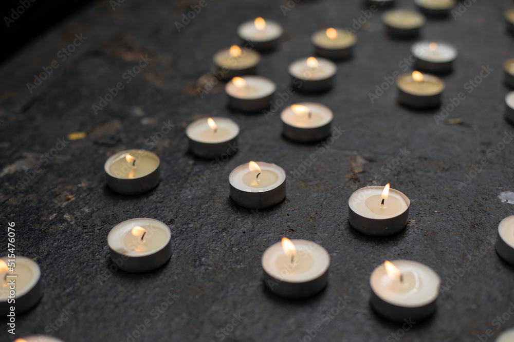 Lots of round candles on grave. Details of memorial ceremony. Candles made of wax. Lots of round candles on grave. Details of memorial ceremony. Candles made of wax.
