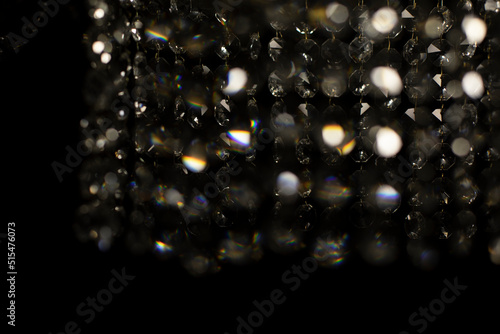 Texture of transparent glass in artificial light. Details of chandelier made of glass in dark.