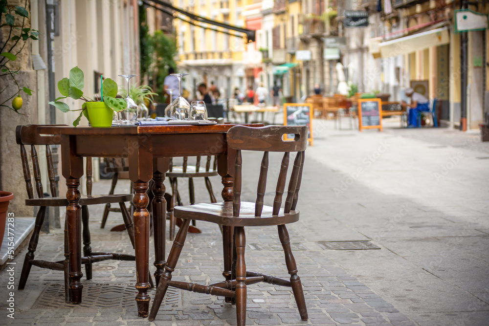 Close Up on Tables and Colored Chairs on the Street Waiting to be Used by Tourists in Summer