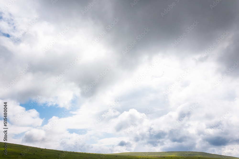 clouds above green hills and meadows. mountain scenery on a sunny day. beautiful summer landscape