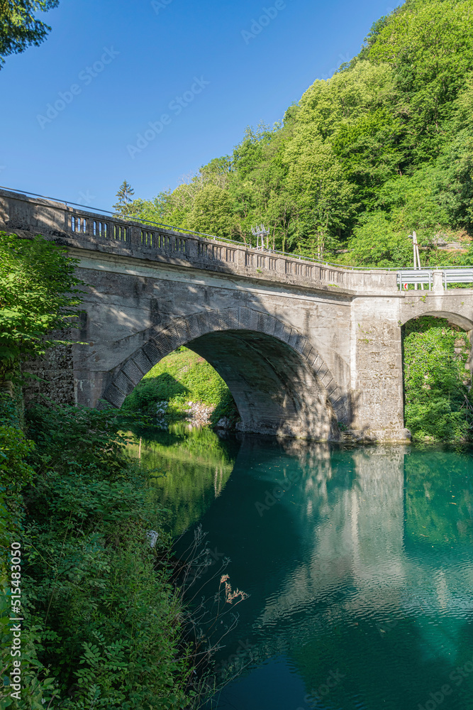 Turquise water in Soca river with old stone bridge in Most Na Soci town,Slovenia.