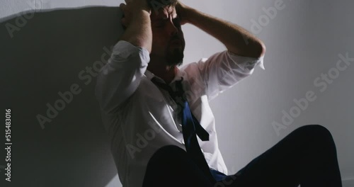 An Insane paranoid man in distress. A mentally ill person suffering from extreme anxiety. A mental disorder person. A mentally mad man in extreme grief. A frustrated man sitting in a room.