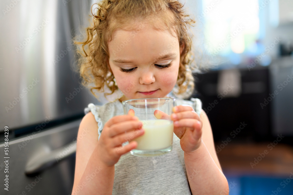 beautiful girl drinks milk on the glass in the kitchen beautiful girl drinks milk on the glass in the kitchen