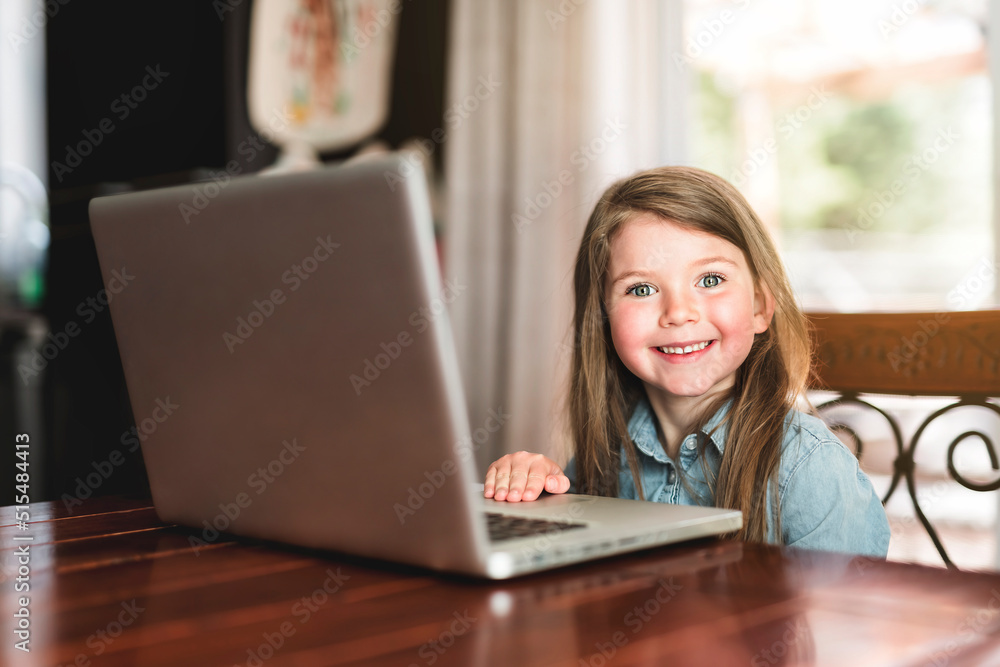 Glad cute girl using laptop at home on table Glad cute girl using laptop at home on table