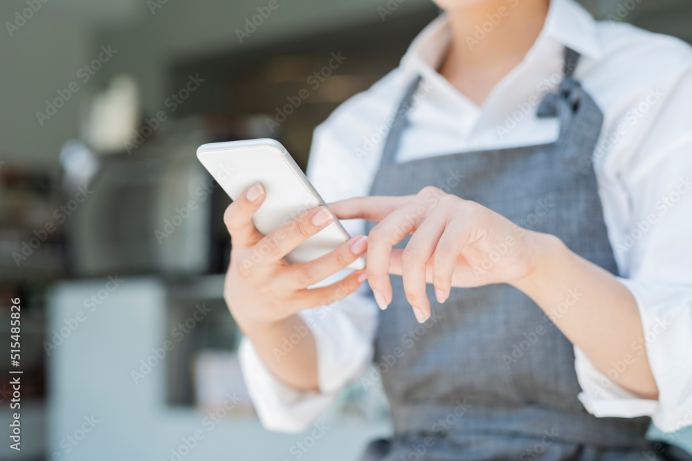 カフェ スマートフォンを使う女性スタッフ カフェ スマートフォンを使う女性スタッフ