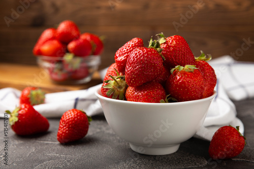 Fresh ripe strawberries in a plate on a black texture background.Vegetarian organic berry.Healthy food.Vitamins.Copy space.Place for text