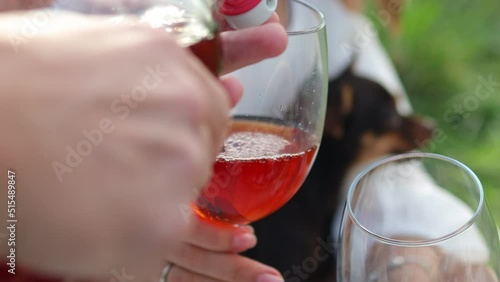 Glass glass filled with red wine. Taster pours alcoholic beverage against the backdrop of the sunset. Romantic dinner in nature. oxidation of wine, oxygenation. 