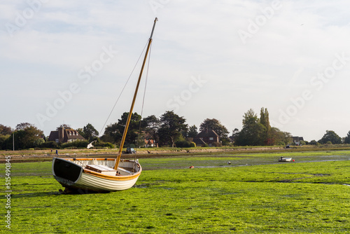 A sailboat lays stranded by the tide