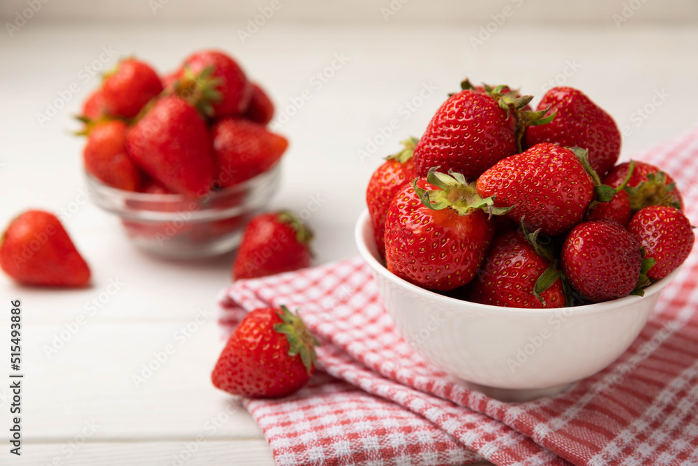 Fresh ripe strawberries in a plate on a white wooden background.Vegetarian organic berry.Healthy food.Vitamins.Copy space.Space for text Fresh ripe strawberries in a plate on a white wooden background.Vegetarian organic berry.Healthy food.Vitamins.Copy space.Space for text