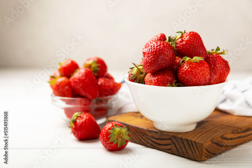 Fresh ripe strawberries in a plate on a white wooden background.Vegetarian organic berry.Healthy food.Vitamins.Copy space.Space for text